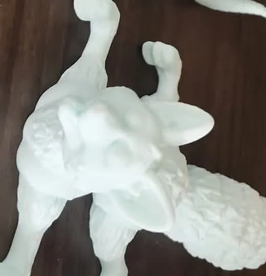 Mint green 3D printed fox statue with a large bushy tail standing on a wooden table