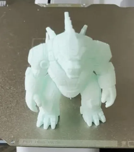 Mint green 3D printed articulated robot gorilla figure standing on the printer build plate