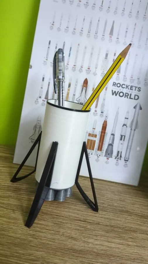 White 3D printed rocket-shaped pencil holder with pens standing inside the booster tubes